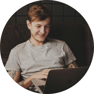 Man sitting smiling at his laptop while on a telehealth consult.